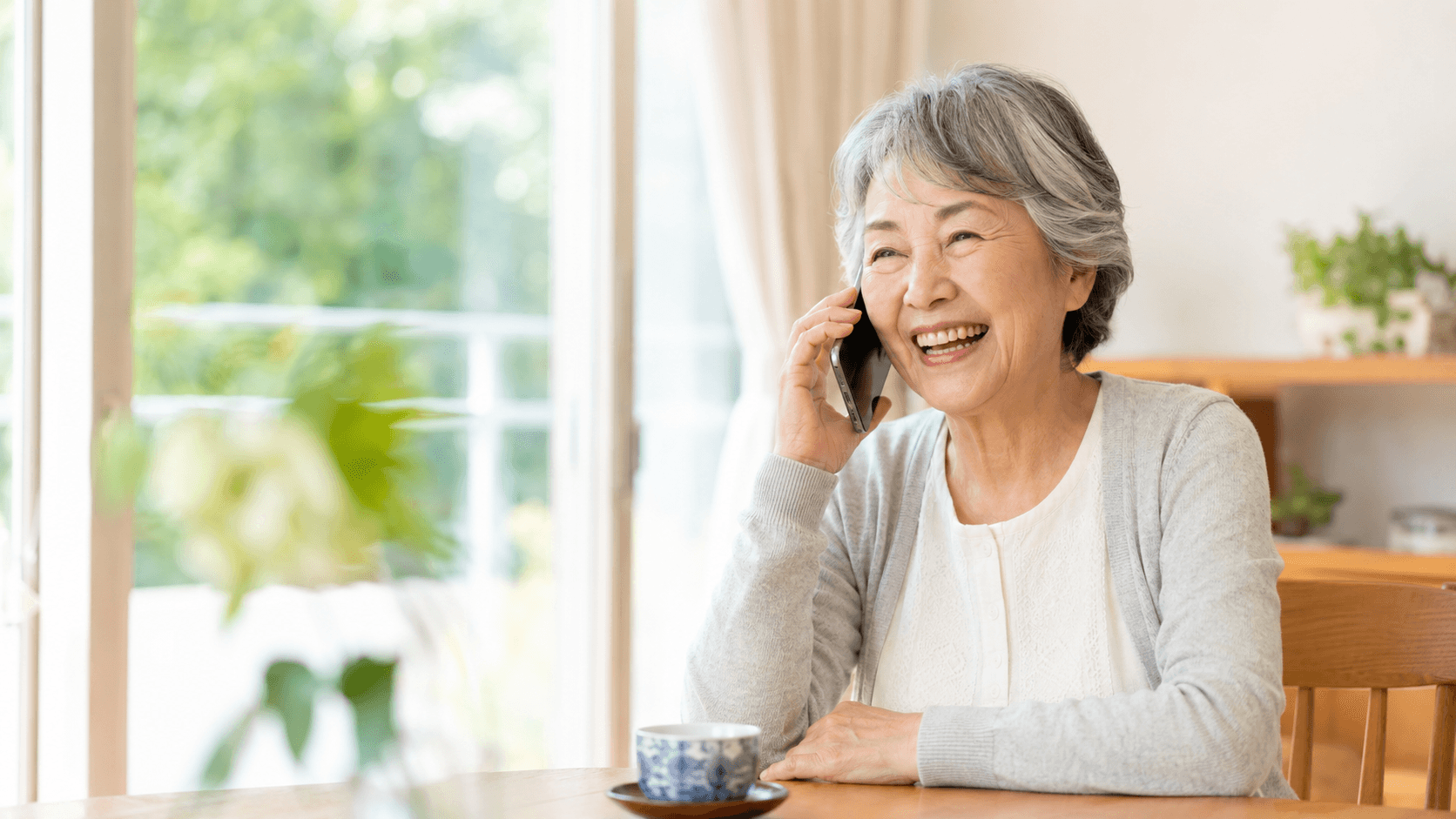 いつもの電話でAIと楽しそうに話す高齢の女性